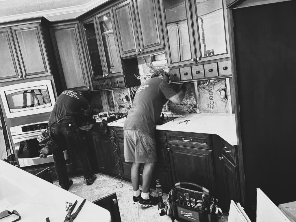 During the Westfield kitchen makeover, the existing backsplash was removed while the stained cabinetry and new white countertops were protected in place.