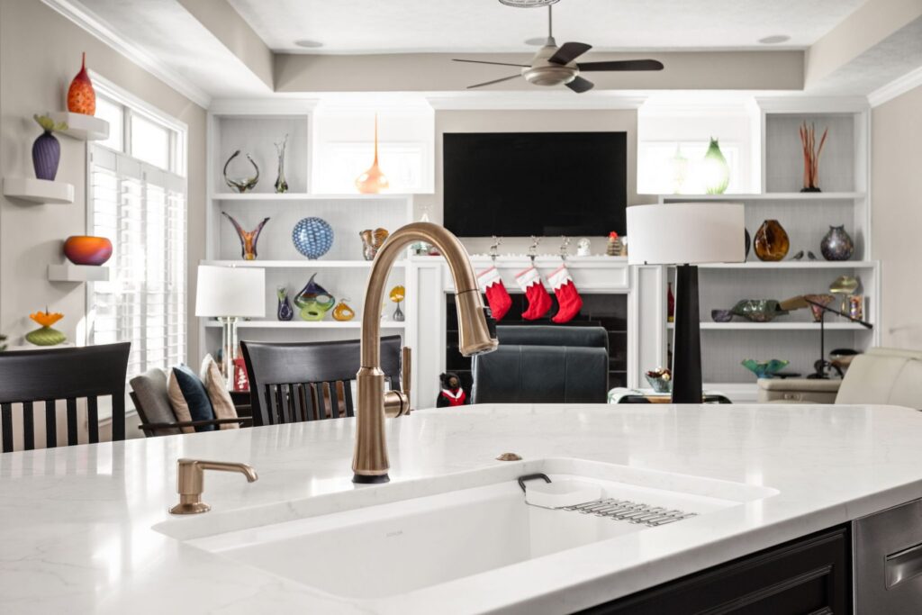 Champagne Bronze fixtures add a warm metallic finish at the island sink.